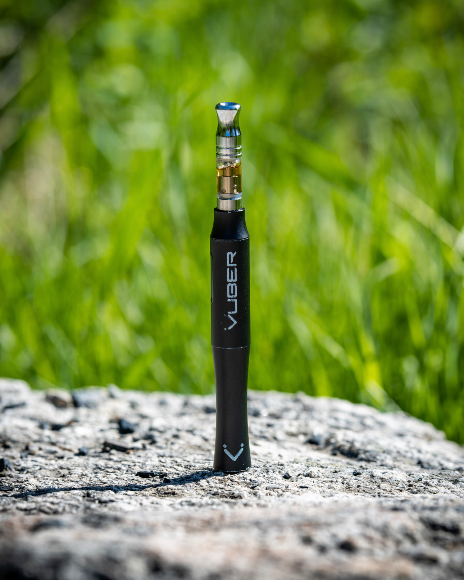Vuber battery with a full quartz cartridge standing on a rock in a green field