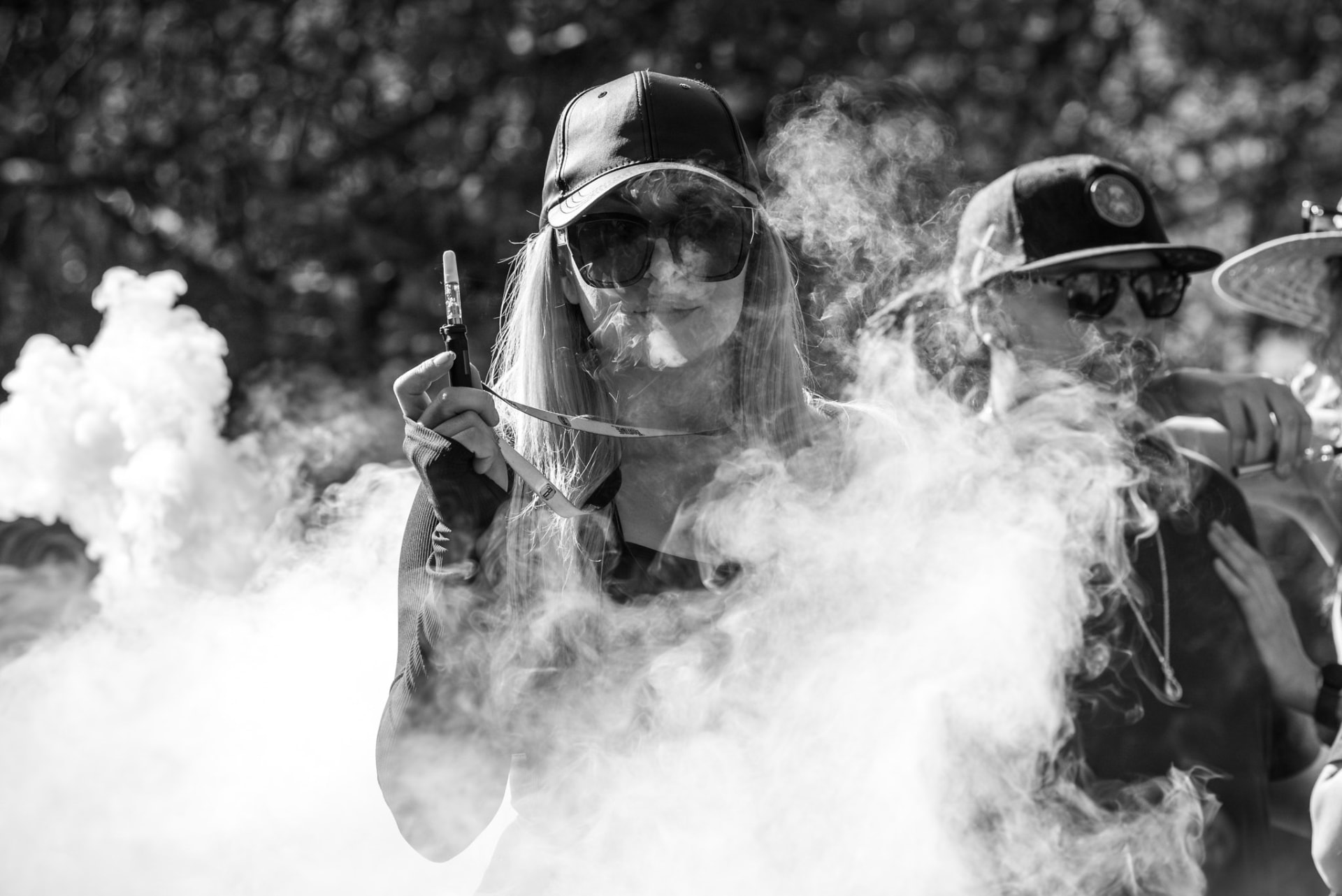 Friends passing a Vuber vaporizer in a cloud of vapor